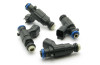 Set of four DeatschWerks 450cc top feed fuel injectors, black bodies with blue O-rings, angled view on white background