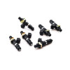 Set of six Deatschwerks 1250cc fuel injectors, black bodies with gold clips, angled view showing electrical connectors.