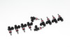 DeatschWerks 1200cc fuel injectors, set of 10, arranged in two staggered rows showing black bodies with red O-rings and connector tips.