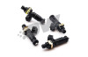 Set of four DeatschWerks EV14 1200cc fuel injectors, black bodies with brass clips, top down angled view.