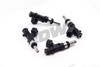 DeatschWerks 1100cc XT fuel injectors for Evo X, four units shown with connectors and O-rings visible, top angle view