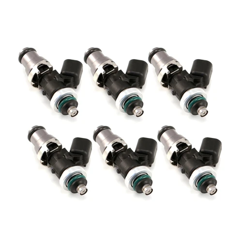 Set of six Injector Dynamics 1050 XDS fuel injectors, angled view showing 14mm adaptor tops and GTR lower spacers with green O-rings.
