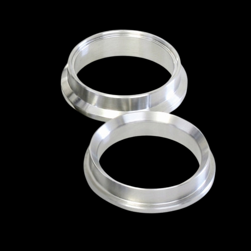Two aluminum Turbosmart WG38 Ultragate valve seats stacked, showing machined flange and bore openings.