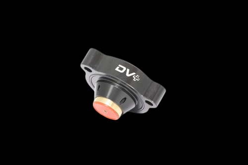 GFB DV+ diverter valve, top down angle showing black flange with mounting holes and orange piston top