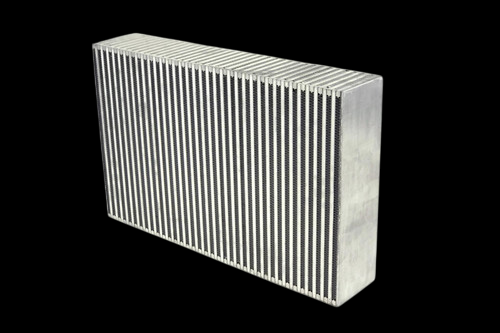 CSF Nissan GT-R R35 bar and plate intercooler core, angled view showing dense fin rows and bare aluminum end tanks.