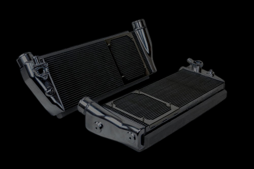 CSF Ferrari 488/Pista intercooler pair, black finish, angled view showing fins, end tanks and inlet fittings.
