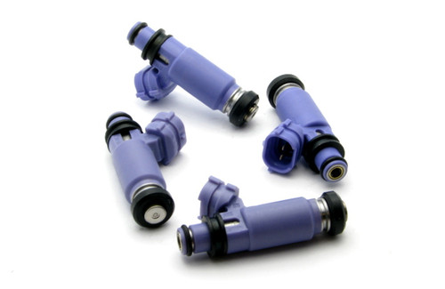 Set of four DeatschWerks 565cc top feed fuel injectors for 02-05 WRX EJ20, purple bodies, black O-rings, electrical connectors visible