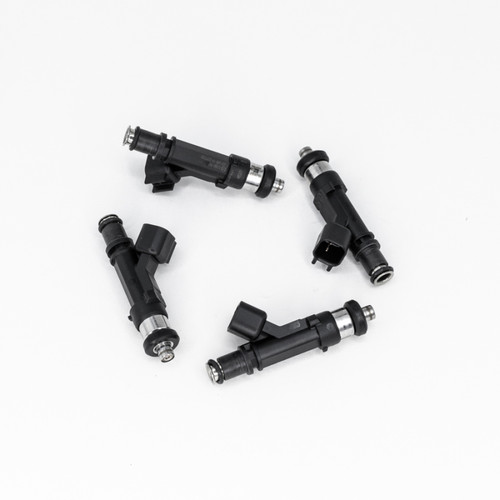 Set of four DeatschWerks 1000cc fuel injectors with connectors, top down angle showing nozzle tips and O-rings.