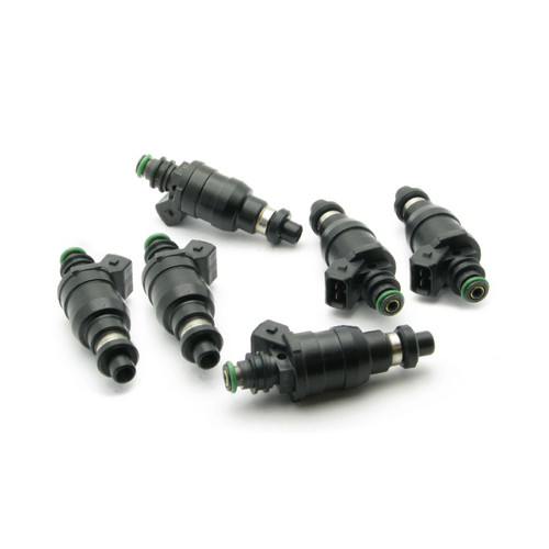 Set of six DeatschWerks 1000cc top feed fuel injectors, black bodies with green O-rings, angled view