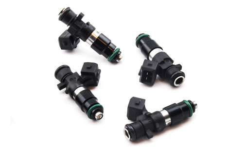 Set of four DeatschWerks EV14 1200cc fuel injectors, black bodies with green O-rings, angled view showing electrical connectors.
