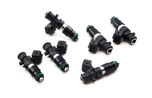 Set of six DeatschWerks EV14 1200cc fuel injectors, black bodies with green O-rings, angled view showing electrical connectors and nozzle tips.