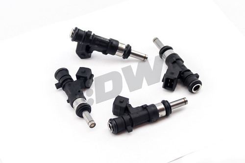 DeatschWerks 1100cc XT fuel injectors for Evo X, four units shown with connectors and O-rings visible, top angle view