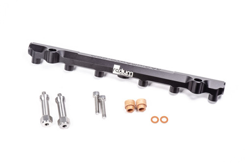 Radium Engineering Mazda 20B REW secondary fuel rail with mounting bolts, spacers and copper sealing washers laid out below it