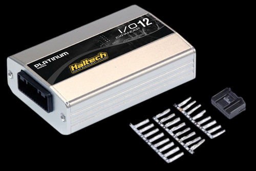Haltech IO 12 Expander Box A with connector plug and pins laid out beside the unit, top angled view