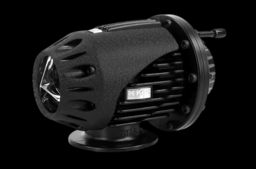 HKS Super SQV4 Black Edition blow off valve, angled side view showing textured body, mounting flange and inlet fitting