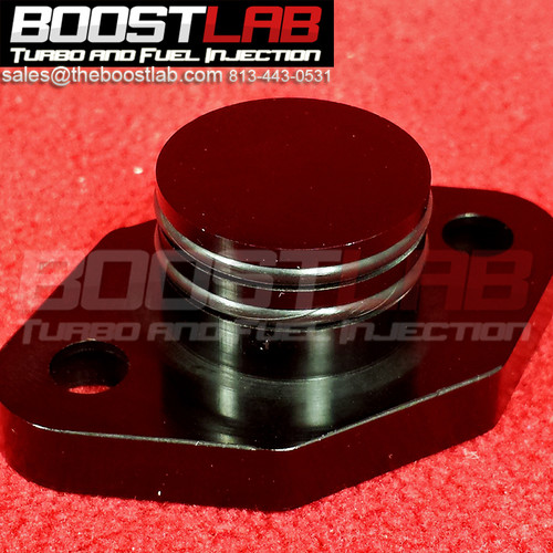 Boost Lab 2JZ-GTE cam angle sensor delete kit, angled top view showing billet flange and round cap plug on red background