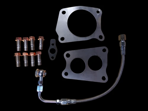 Boost Lab TD06SL2-54X turbo kit hardware, mounting flanges, oil line, and bolts on black background