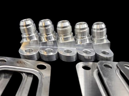 Turbo Gasket Shop Kit, five AN fittings on machined blocks lined up beside flat steel gaskets