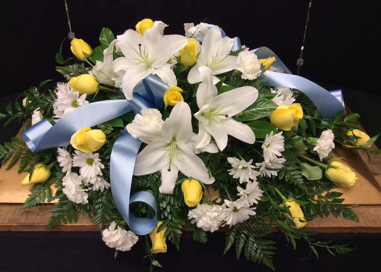 1/2 Couch Casket Spray in pale yellows, whites, and blues Centerville