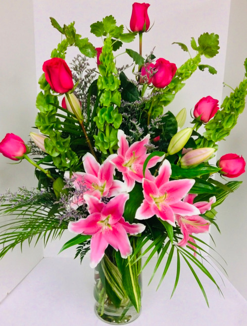 Bells, Lilies, Hot Pink Roses, and Robellini Palms Grande Vase