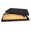 A wooden serving board with a round handle inside a black box. The board features a natural wood finish.