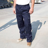 Action trousers in navy blue with multiple pockets, worn by a person on a construction site.