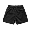 Black youth rugby shorts with an elastic waistband and drawstring fastening, featuring a logo.