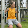 A yellow youth singlet, featuring a logo, worn by a boy sitting on playground equipment in a garden setting.