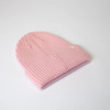 A pink ribbed beanie with a folded brim and a small logo on the side.