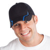 A black cap with blue accents and a branding logo, worn by a smiling man.