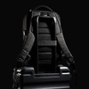 A black Swissdigital Arosa Backpack rests on a suitcase, featuring straps and a sleek design.