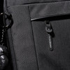 A black laptop sleeve with a zippered pocket and a branded tag. Features a keychain accessory attached.