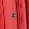 A close-up of a red fabric detail featuring a zipper and a decorative snap button, showcasing the material texture.
