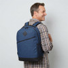 A blue backpack with black accents, worn on a man's back, featuring a logo on the front.