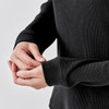 A black crew neck shirt with textured fabric, featuring fitted sleeves and a snug fit around the wrists.
