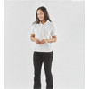 A woman stands wearing a white polo shirt and black pants. The shirt has a logo on it.