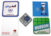 A selection of custom PVC coasters in various shapes and colours, featuring logos and designs.