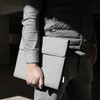 A grey business folio held by a person in a grey shirt, showcasing a simple, sleek design.
