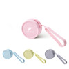 A round silicone coin pouch in pink, with a matching strap, alongside pouches in blue, yellow, and grey. It features a logo.