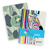 A large notebook featuring a leaf-patterned cover and a vibrant zebra design, with branding elements.