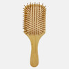 A bamboo hairbrush with a wooden handle and bristles, featuring a rectangular paddle design.