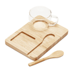 A bamboo tray with a clear glass cup and a wooden spoon. The set is minimalistic and natural in style.