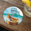 A round coaster featuring a vibrant illustration of prawns on a drink, with a glossy finish and a logo.