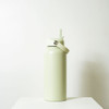 A drink bottle in a light green hue with a flip-top lid and a metal loop for easy carrying.