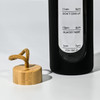 A drink bottle with a black body and a bamboo lid, featuring time markers on the side for hydration reminders.
