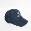 A navy blue baseball cap with a Velcro strap and a logo on the front, featuring six panels.