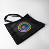 A black nylon mesh tote bag featuring a circular logo in the centre and two sturdy handles.