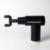 A black and gold massage gun with a unique hook attachment and a sleek design. It features a noticeable logo.
