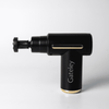 A black massage gun with gold accents and a branding logo, featuring an adjustable head for targeted relief.