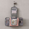 A travel storage bag in grey and pink, featuring compartments filled with toiletries and cosmetic items.